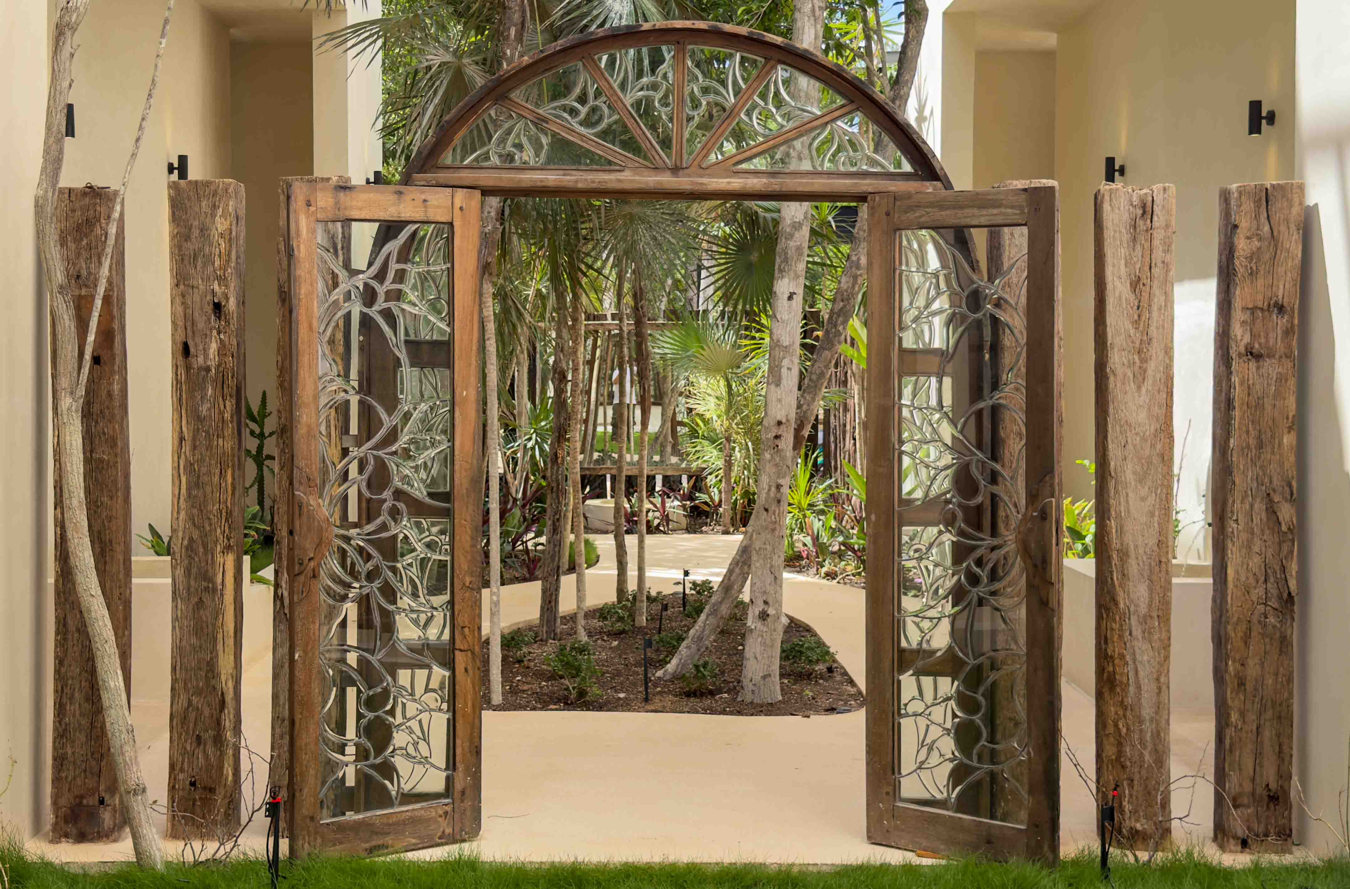 Ornate carved wood and glass entrance gates opening into the courtyard