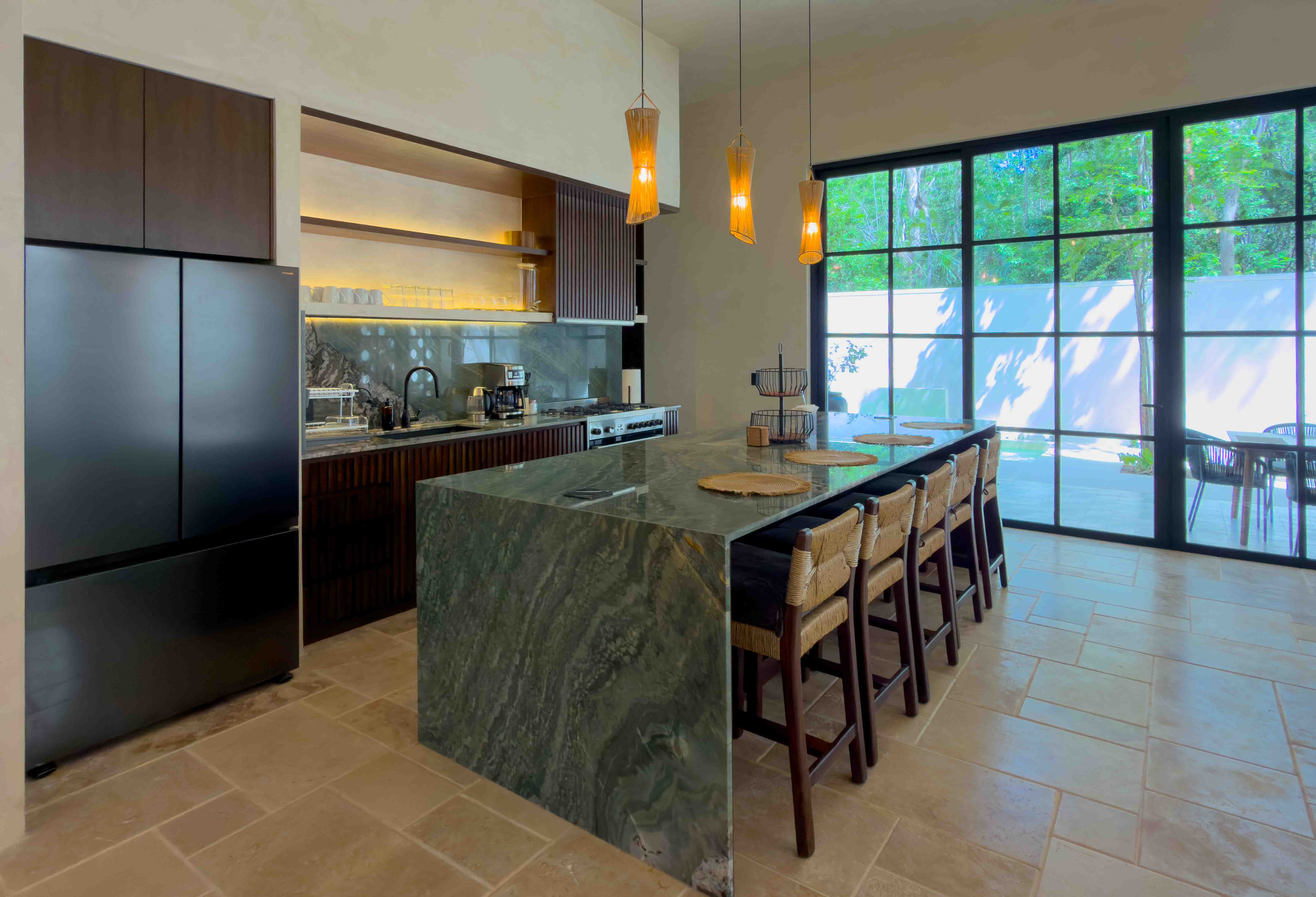 Modern kitchen with a green-marble waterfall island and floor-to-ceiling windows